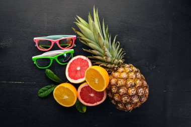 Ananas ve narenciye ahşap arka plan üzerinde. Tropikal meyve ve fındık. Üstten Görünüm. Metin için boş alan.