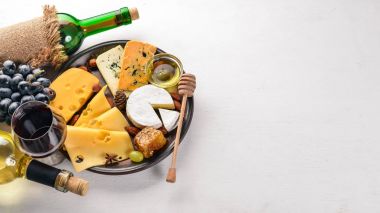 Gıda arka plan peynir ile. Küflü peynir, üzüm, bal, beyaz arka plan üzerinde fındık bloklarını. Uzay kopyalayın. Üstten Görünüm.