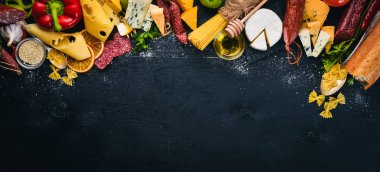 Çeşitli peynir, sosis, şaraplar, geleneksel baharat ve ahşap arka plan üzerinde taze sebze. Peynir brie, mavi peynir, gorgonzola, fuete, salam. İtalyan ve İspanyol mutfağı. Boş alan.