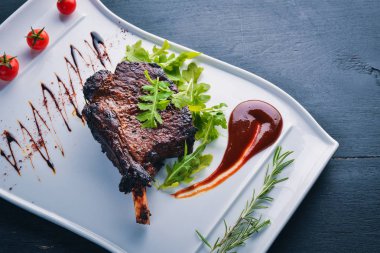 Domates ve bir fındık ile bir kemik biftek. Biftek Fiorentino. Ahşap bir arka plan üzerinde. Metniniz için boş alan. Üstten Görünüm.