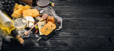 Ürün yelpazesine peynirler, brie peyniri, gorgonzola, mavi peynir, üzüm, bal, fındık, kırmızı ve beyaz şarap, ahşap bir masa üzerinde bir büyük. Üstten Görünüm. Metin için boş alan.