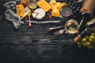 Ürün yelpazesine peynirler, brie peyniri, gorgonzola, mavi peynir, üzüm, bal, fındık, kırmızı ve beyaz şarap, ahşap bir masa üzerinde bir büyük. Üstten Görünüm. Metin için boş alan.