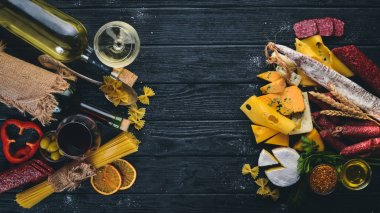 Bir şişe şarap, peynir ve ahşap arka plan üzerinde geleneksel sosis. Brie peyniri, mavi peynir, gorgonzola, fuete, salam. Metin için özgür yer. Üstten Görünüm.
