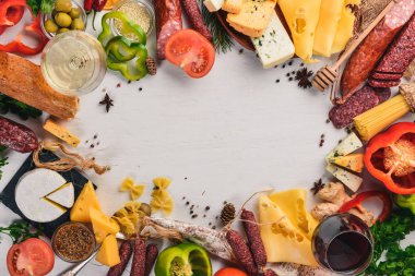 Çeşitli peynirler ve geleneksel sosis ve sebze Beyaz ahşap zemin üzerinde. Peynir brie, mavi peynir, gorgonzola, fuete, salam. Geleneksel İtalyan mutfağı. Metin için özgür yer. Üstten Görünüm.