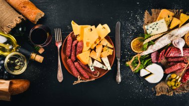 Çeşitli peynir, sosis, şaraplar, geleneksel baharat ve ahşap arka plan üzerinde taze sebze. Peynir brie, mavi peynir, gorgonzola, fuete, salam. İtalyan ve İspanyol mutfağı. Boş alan.