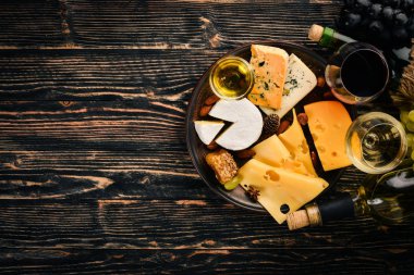 Ürün yelpazesine peynirler, brie peyniri, gorgonzola, mavi peynir, üzüm, bal, fındık, kırmızı ve beyaz şarap, ahşap bir masa üzerinde bir büyük. Üstten Görünüm. Metin için boş alan.