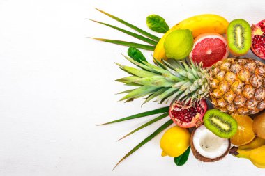 Taze tropikal meyve. Ananas, Hindistan cevizi, kivi, portakal, nar, greyfurt. Ahşap bir arka plan üzerinde. Üstten Görünüm. Metin için boş alan.
