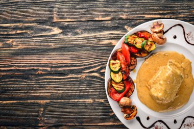 Eti biftek sosu ve ızgara sebzeler. Biftek Voronov. Ahşap bir arka plan üzerinde. Metniniz için boş alan. Üstten Görünüm.