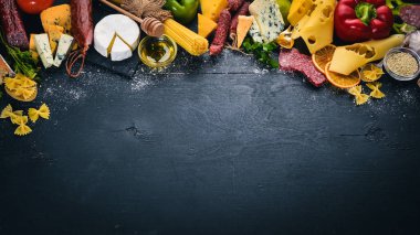 Çeşitli peynir, sosis, şaraplar, geleneksel baharat ve ahşap arka plan üzerinde taze sebze. Peynir brie, mavi peynir, gorgonzola, fuete, salam. İtalyan ve İspanyol mutfağı. Boş alan.