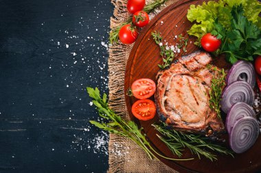 Sebzeli ızgara biftek. Domuz eti, Dana eti, et. Ahşap bir arka plan üzerinde. Üstten Görünüm. Metin için boş alan.