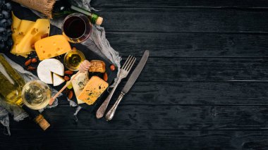 Ürün yelpazesine peynirler, brie peyniri, gorgonzola, mavi peynir, üzüm, bal, fındık, kırmızı ve beyaz şarap, ahşap bir masa üzerinde bir büyük. Üstten Görünüm. Metin için boş alan.