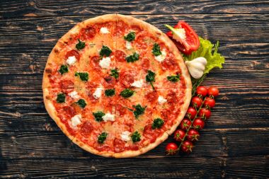 Napolice Pizza. Ispanak, gorgonzola peyniri, sosis salam. Ahşap bir arka plan üzerinde. Üstten Görünüm.