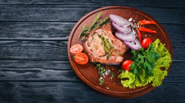 Sebzeli ızgara biftek. Domuz eti, Dana eti, et. Ahşap bir arka plan üzerinde. Üstten Görünüm. Metin için boş alan.