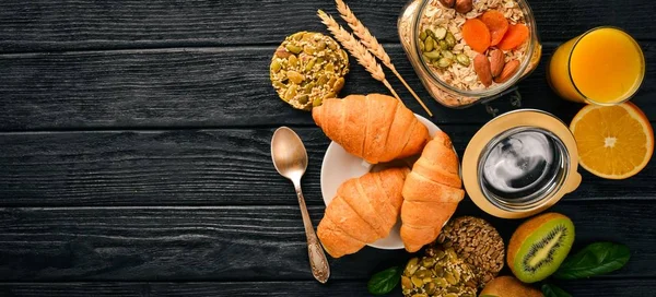 Sağlıklı Diyet kahvaltı. Fındık, yulaf gevreği, meyve, kruvasan, ahşap bir yüzey üzerinde. Üstten Görünüm. Metin için boş alan.