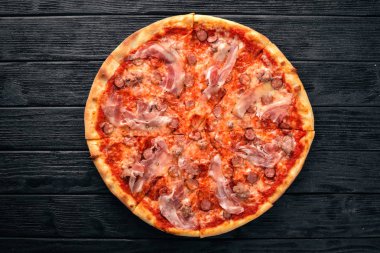 Pizza Lardon. Pastırma, domates, sosis salam. Ahşap bir arka plan üzerinde. Üstten Görünüm.