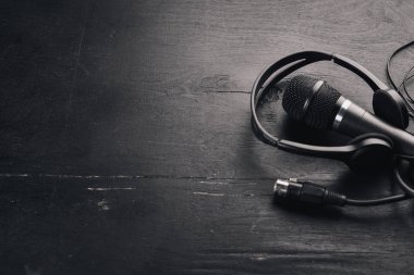 Kulaklık ve mikrofon ahşap bir siyah masa üzerinde. Stüdyo. Üstten Görünüm. Metin için özgür yer. Kopya alanı.
