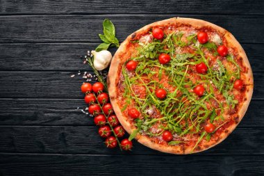 Pizza Primavera. Kiraz domates, roka, peynir. Ahşap bir arka plan üzerinde. Üstten Görünüm.