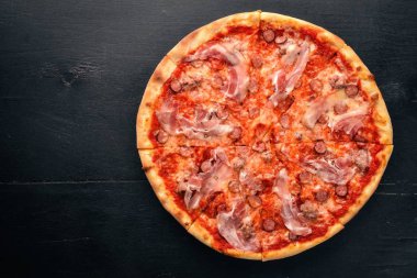 Pizza Lardon. Pastırma, domates, sosis salam. Ahşap bir arka plan üzerinde. Üstten Görünüm.