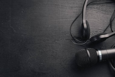 Kulaklık ve mikrofon ahşap bir siyah masa üzerinde. Stüdyo. Üstten Görünüm. Metin için özgür yer. Kopya alanı.