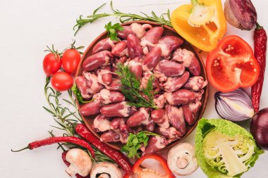 Çiğ tavuk kupa rosemary ile yemek pişirmek için hazır plaka üzerinde ve üzerinde baharat beyaz ahşap arka plan. Üstten Görünüm. Metin için boş alan.