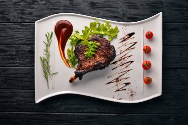 Domates ve bir fındık ile bir kemik biftek. Biftek Fiorentino. Ahşap bir arka plan üzerinde. Metniniz için boş alan. Üstten Görünüm.