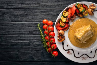 Eti biftek sosu ve ızgara sebzeler. Biftek Voronov. Ahşap bir arka plan üzerinde. Metniniz için boş alan. Üstten Görünüm.