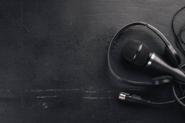 Kulaklık ve mikrofon ahşap bir siyah masa üzerinde. Stüdyo. Üstten Görünüm. Metin için özgür yer. Kopya alanı.