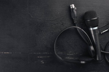 Kulaklık ve mikrofon ahşap bir siyah masa üzerinde. Stüdyo. Üstten Görünüm. Metin için özgür yer. Kopya alanı.