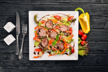 Dana salata, marul ve plaka üzerinde taze sebze. Ahşap bir arka plan üzerinde. Üstten Görünüm. Metin için boş alan.