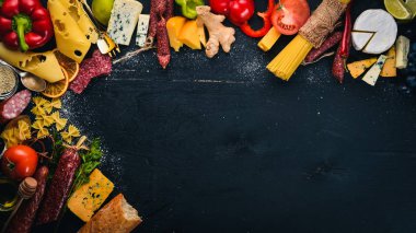 Çeşitli peynir, sosis, şaraplar, geleneksel baharat ve ahşap arka plan üzerinde taze sebze. Peynir brie, mavi peynir, gorgonzola, fuete, salam. İtalyan ve İspanyol mutfağı. Boş alan.