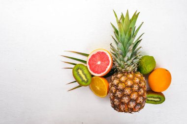 Taze tropikal meyve. Hindistan cevizi, ananas, kivi ve greyfurt. Ahşap bir arka plan üzerinde. Üstten Görünüm. Metin için boş alan.