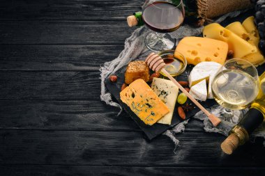 Ürün yelpazesine peynirler, brie peyniri, gorgonzola, mavi peynir, üzüm, bal, fındık, kırmızı ve beyaz şarap, ahşap bir masa üzerinde bir büyük. Üstten Görünüm. Metin için boş alan.