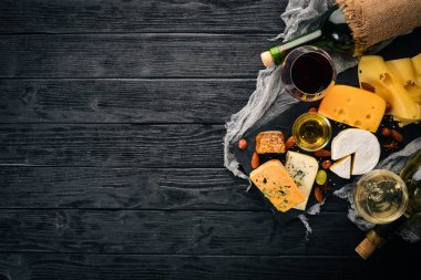 Ürün yelpazesine peynirler, brie peyniri, gorgonzola, mavi peynir, üzüm, bal, fındık, kırmızı ve beyaz şarap, ahşap bir masa üzerinde bir büyük. Üstten Görünüm. Metin için boş alan.