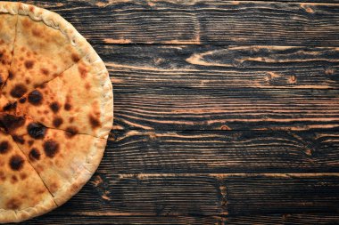 Pizza volkan. Gorgonzola peyniri, domates, taze sebze ve baharat. Ahşap bir arka plan üzerinde. Metniniz için boş alan. Üstten Görünüm.