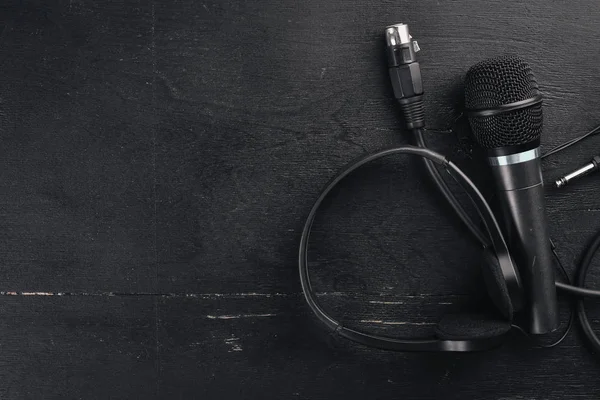 Kulaklık ve mikrofon ahşap bir siyah masa üzerinde. Stüdyo. Üstten Görünüm. Metin için özgür yer. Kopya alanı.