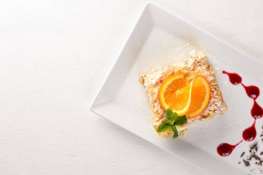 Portakal lezzet ile katmanlı pasta. Ahşap bir arka plan üzerinde. Metniniz için boş alan. Üstten Görünüm.