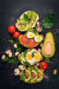 Avokado sandviç, kiraz domates ve bıldırcın yumurtası ve chia tohum kümesi. Ahşap bir arka plan üzerinde. Üstten Görünüm. Metniniz için boş alan.