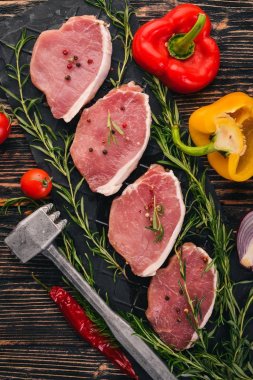 Taze sebze ve biberiye ve baharat siyah ahşap zemin sığır eti biftek. Üstten Görünüm. Metin için boş alan.