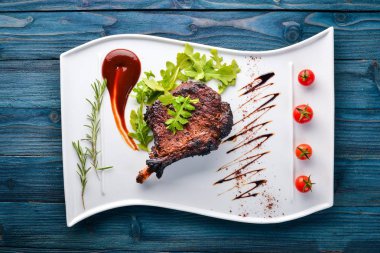 Domates ve bir fındık ile bir kemik biftek. Biftek Fiorentino. Ahşap bir arka plan üzerinde. Metniniz için boş alan. Üstten Görünüm.