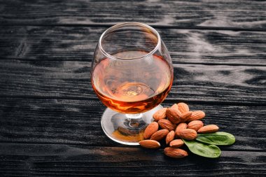 Amaretto badem likörü. Badem ahşap arka plan üzerinde. İtalyan içki üstten görünüm. Metin için boş alan.
