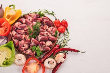 Çiğ tavuk kupa rosemary ile yemek pişirmek için hazır plaka üzerinde ve üzerinde baharat beyaz ahşap arka plan. Üstten Görünüm. Metin için boş alan.