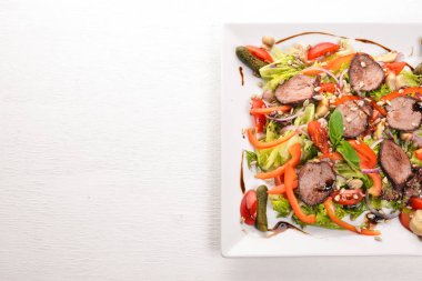 Dana salata, marul ve plaka üzerinde taze sebze. Ahşap bir arka plan üzerinde. Üstten Görünüm. Metin için boş alan.