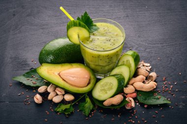 Avokado ve salatalık keten tohumu ve fındık ile güler yüzlü. Ahşap bir arka plan üzerinde. Üstten Görünüm. Metniniz için boş alan.