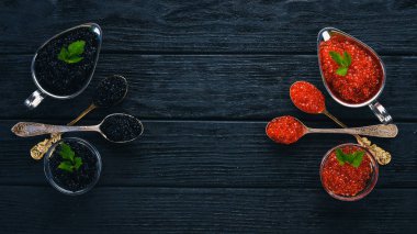 Ahşap arka plan üzerinde siyah ve kırmızı havyar kaşıkla. Üstten Görünüm. Metin için boş alan.