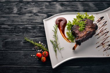 Domates ve bir fındık ile bir kemik biftek. Biftek Fiorentino. Ahşap bir arka plan üzerinde. Metniniz için boş alan. Üstten Görünüm.