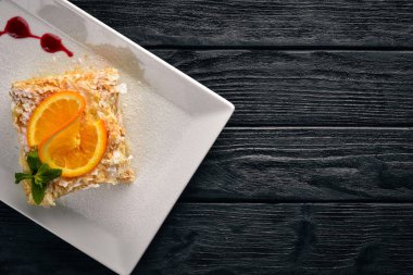 Portakal lezzet ile katmanlı pasta. Ahşap bir arka plan üzerinde. Metniniz için boş alan. Üstten Görünüm.