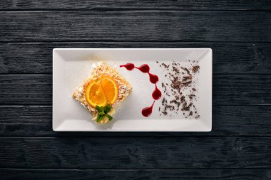 Portakal lezzet ile katmanlı pasta. Ahşap bir arka plan üzerinde. Metniniz için boş alan. Üstten Görünüm.