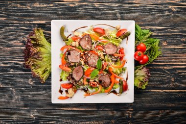 Dana salata, marul ve plaka üzerinde taze sebze. Ahşap bir arka plan üzerinde. Üstten Görünüm. Metin için boş alan.