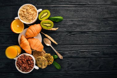 Fitness Kahvaltı, müsli, süt, meyve, fındık ve tohumlar, bir ahşap yüzeyde. Üstten Görünüm. Metin için boş alan.