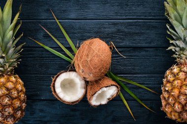 Hindistan cevizi ve ananas ahşap arka plan üzerinde. Tropikal meyve ve fındık. Üstten Görünüm. Metin için boş alan.